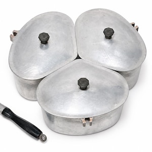May include: Three silver-coloured metal cooking pots with rounded triangular shapes and matching lids, each featuring a small black hexagonal knob. A detachable black handle with a silver-coloured metal attachment is positioned separately.