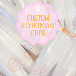 May include: A collection of white styrofoam cups stacked in clear plastic packaging. Each cup features various printed designs in pink and orange ink, including text such as 'congrats VINE HOUSE UNIVERSITY OF TENNESSEE' and 'Bryson'.
