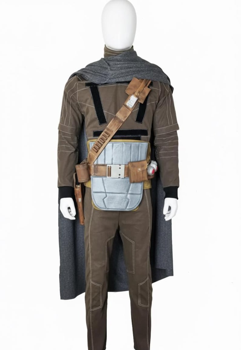 May include: A brown and gray costume with a cape, designed to resemble a character from a science fiction film. The costume includes a long-sleeved shirt, pants, a belt with pouches, and a chest plate. A gray scarf is draped around the neck.