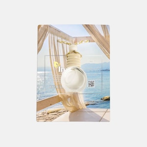 Könnte beinhalten: Eine klare, runde Glasflasche mit Holzaufsatz und dekorativem Element, vermutlich ein Lufterfrischer. Die Flasche befindet sich vor einer Strandszene mit dem Wort "Beach". Ein QR-Code ist ebenfalls vorhanden.