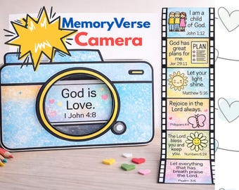 Puede incluir: Una cámara Memory Verse azul claro y blanca con el texto "Dios es Amor. I Juan 4:8" en la lente. Una tira de película con versículos bíblicos está a la derecha. La palabra "Camera" es roja.