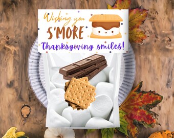 May include: A clear plastic treat bag filled with white marshmallows, a brown chocolate bar, and tan graham crackers. The top features a white card with colorful dots and the text "Wishing you S'MORE Thanksgiving smiles!" and a s'more illustration.