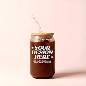Puede incluir: Un vaso de cristal con forma de lata lleno de un líquido marrón oscuro, con tapa de bambú y pajita de cristal transparente. El frente del vaso muestra el texto blanco "YOUR DESIGN HERE" con iconos de estrellas y texto descriptivo debajo.