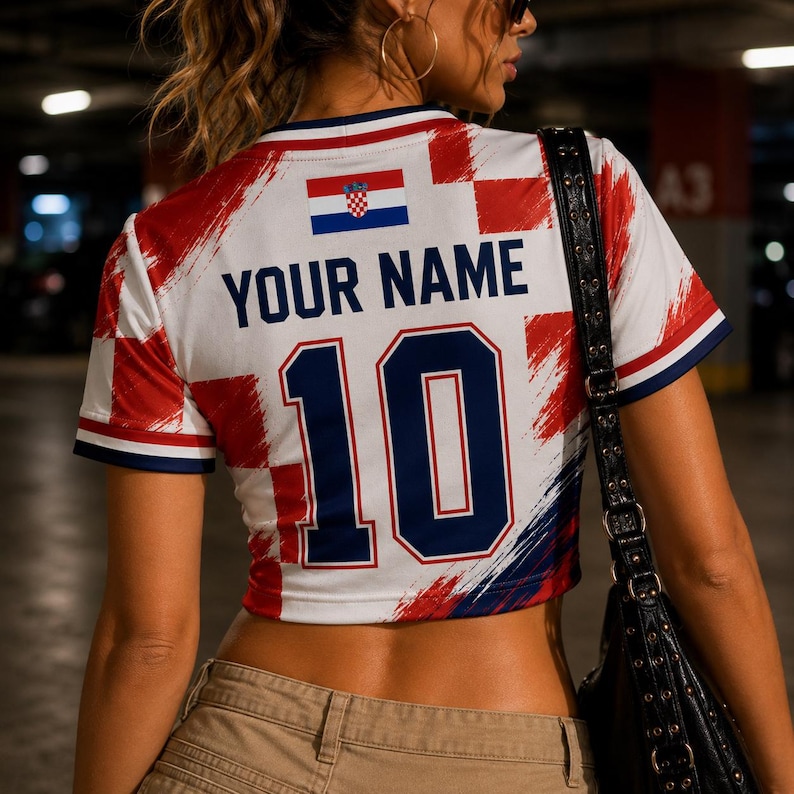May include: A white crop top with a Croatian flag design, featuring red and white checkered patterns and blue accents. The shirt displays the text "YOUR NAME" above the number "10".
