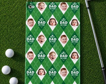 Puede incluir: Toalla de golf verde con un patrón de diamantes y las palabras "BEST DAD BY PAR" repetidas. La toalla presenta múltiples caras de bebé. Un palo de golf y pelotas de golf están en el fondo.