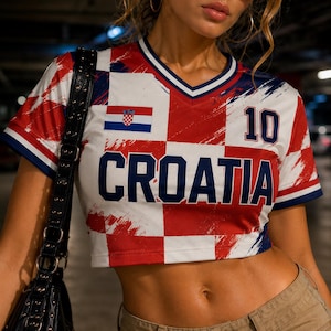 May include: Croatia-themed crop top in red, white, and blue checkered pattern. Features the Croatian flag and the word "CROATIA" in bold blue letters. The number "10" is printed on the top. The top has a V-neck and short sleeves.