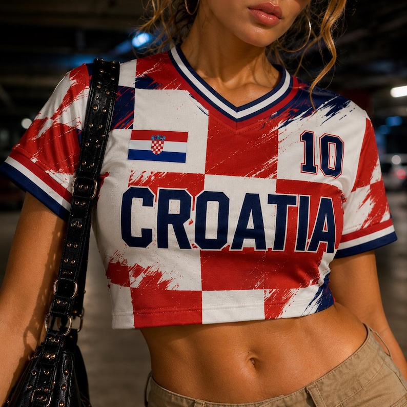 May include: Croatia-themed crop top in red, white, and blue checkered pattern. Features the Croatian flag and the word "CROATIA" in bold blue letters. The number "10" is printed on the top. The top has a V-neck and short sleeves.
