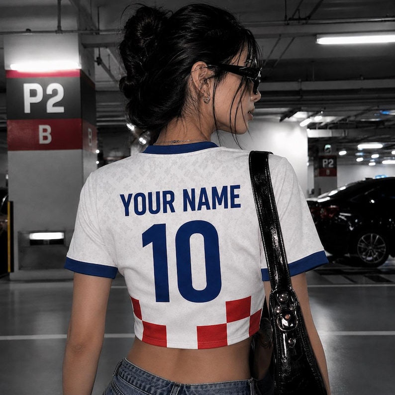 May include: White crop top with blue trim and the number 10 in blue. The shirt has the text "YOUR NAME" above the number. The bottom of the shirt has a red and white checkered pattern.