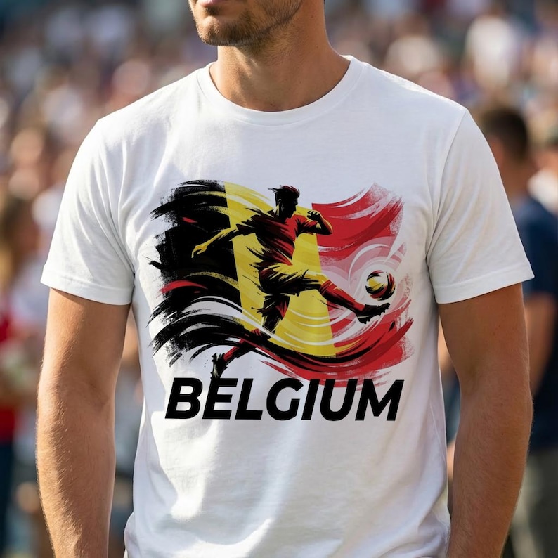 Puede incluir: Camiseta blanca con un jugador de f&uacute;tbol pateando un bal&oacute;n, con los colores de la bandera belga: negro, amarillo y rojo. La palabra "BELGIUM" est&aacute; impresa en letras negras en negrita debajo de la imagen.