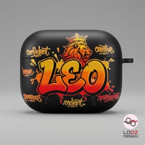 May include: Black AirPod case with a graffiti-style design. The case features the word "LEO" in orange and yellow, a lion illustration, and words like "confident" and "creative". The case has a glossy finish.