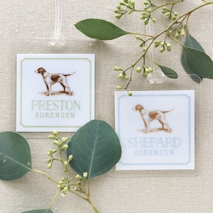 May include: Two white rectangular cards with green and blue borders. Each card features a brown line drawing of a dog, with the name "Preston Sorensen" on the green card and "Shepard Sorensen" on the blue card.