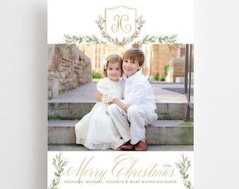 May include: A Christmas card featuring a watercolor illustration of a wreath with holly berries and a gold monogram "HC". The card also features a photo of two children sitting on steps, smiling at the camera. The text "Merry Christmas 2022" is written in gold script below the photo, with the names "Shannon, Michael, Coleman & Mary Mathis Havranek" written in smaller font below the greeting.