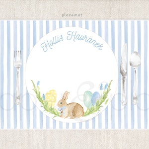 May include: Blue and white striped placemat with a white plate featuring a bunny rabbit, Easter eggs, and flowers. The plate has the name "Hollis Hawranek" written on it.