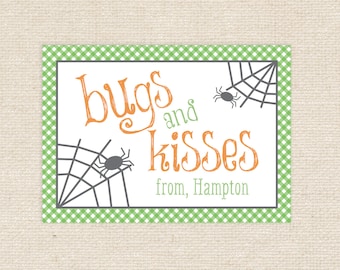 May include: A green and white gingham card with the text "bugs and kisses" in orange and grey. The card also features two black spiders on a grey web.