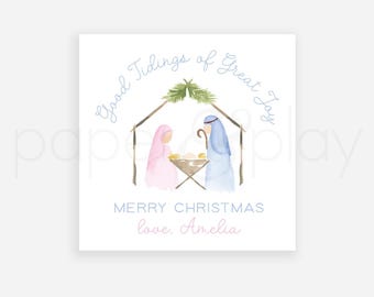 May include: A watercolour illustration of a Nativity scene with the text "Good Tidings of Great Joy" and "Merry Christmas love, Amelia". The image features a pink-robed figure, a blue-robed figure, and a manger.