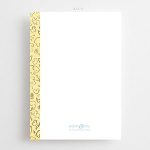 Pu&ograve; includere: Un biglietto bianco con un bordo giallo con un motivo di piccoli animali e fiori. Il testo "paper & play" e "paperandplay.com" &egrave; stampato in blu nella parte inferiore del biglietto.
