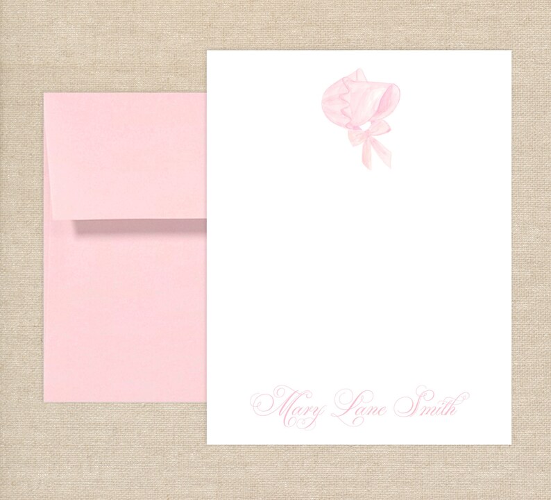 May include: Pink stationery set with a pink bonnet illustration and the name "Mary Lane Smith" in cursive script.