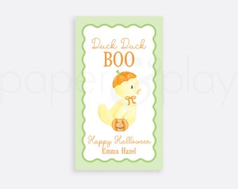 May include: A light green rectangular card with a scalloped border features a watercolor illustration of a yellow duck wearing a pumpkin hat and holding a jack-o'-lantern. The text reads "Duck Duck BOO" and "Happy Halloween Emma Hazel".