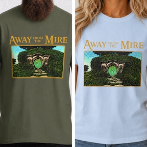May include: Two t-shirts, one olive green and one light blue, each displaying the text "Away From the Mire" above a graphic of a green door set into a hillside. The graphic is framed in a rectangle.