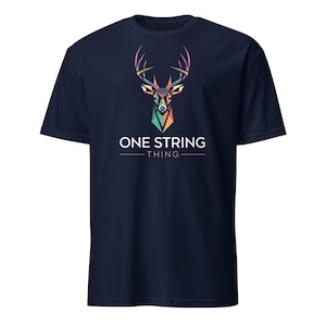 Pode incluir: Camiseta azul marinho com um design geométrico de cabeça de veado em tons de laranja, verde e roxo. O texto "ONE STRING THING" está impresso em branco abaixo.