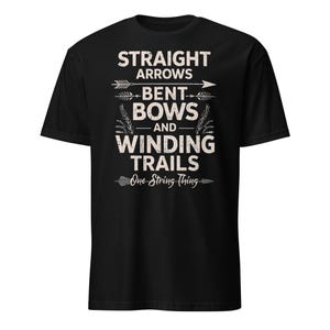 Pode incluir: Camiseta preta com texto branco: "STRAIGHT ARROWS, BENT BOWS, AND WINDING TRAILS" com gráficos de flechas e arcos. Abaixo, a frase "One String Thing".