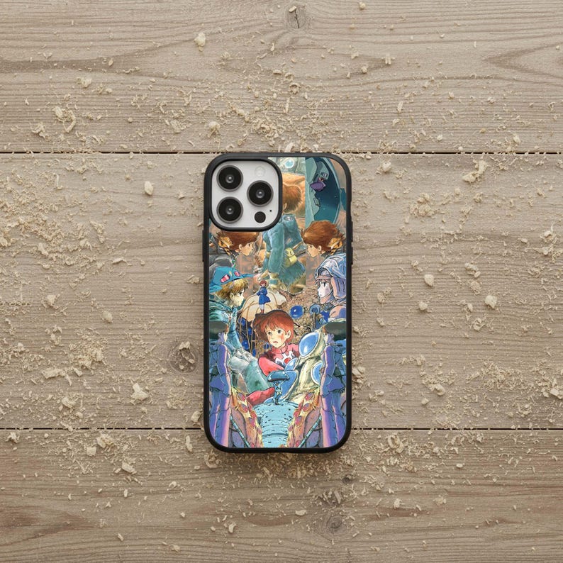 May include: Black phone case featuring a colorful anime-style illustration. The artwork depicts several characters in a fantasy setting with a variety of colors, including blue, red, and brown. The case has a black border and a glossy finish.