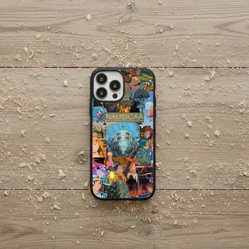 May include: Black phone case featuring a collage of colorful anime-style illustrations. The word "NAUSICAA" is printed on the case. The case has a black border and a glossy finish.