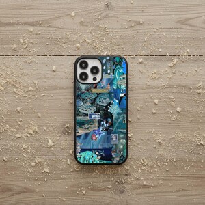 May include: A black iPhone case featuring a collage of blue and teal images with the word "NAUSICAA" visible. The case has a glossy finish and a black border, set against a light brown wooden surface.