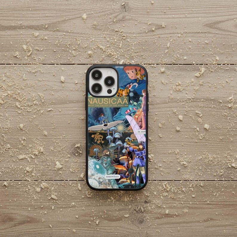 May include: Black iPhone case featuring a colorful collage of anime art with the text "NAUSICA&Auml; OF THE VALLEY OF THE WIND". The case has a glossy finish and a black border, showcasing a vibrant design.