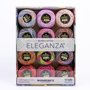 May include: A box containing 12 balls of WonderFil Eleganza #8 Perle Cotton thread. Each ball is 5g and made of 100% Egyptian cotton. The packaging displays the brand name Eleganza, the thread weight, and the total length of 42 yards per ball.