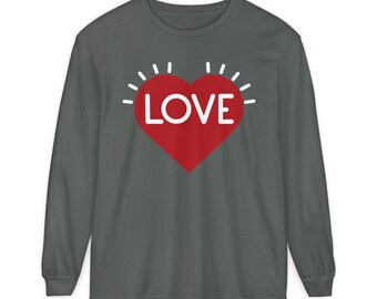 May include: Dark gray long-sleeve shirt featuring a red heart with the word "LOVE" in white. The heart has white radiating lines around it. The shirt is a solid color and has a crew neck.