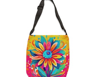 May include: A colorful shoulder bag with a black strap. The bag features a large, vibrant floral design in shades of yellow, pink, blue, and orange. The floral pattern is set against a yellow background with pink accents.
