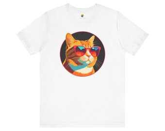 May include: White t-shirt featuring a cartoon image of an orange tabby cat wearing red sunglasses. The cat is inside a black circle. The shirt has a crew neck and short sleeves. The cat's sunglasses have a gradient of orange, red, and blue.