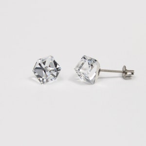 May include: A pair of silver stud earrings with clear cubic zirconia stones. The stones are faceted and have a square shape.