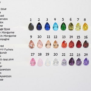 May include: Chart of 24 teardrop-shaped gemstones in various colors, numbered 1 through 24. The colors include black, navy, royal blue, aqua, emerald, peridot, citrine, vintage rose, pink morganite, peach morganite, champagne, red, dark red, cherry fuchsia, burgundy, pink, blush opal pink, opal, clear, light amethyst, plum, dark amethyst, and purple.