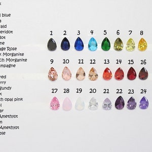 May include: Chart of 24 teardrop-shaped gemstones in various colors, numbered 1 through 24. The colors include black, navy, royal blue, aqua, emerald, peridot, citrine, vintage rose, pink morganite, peach morganite, champagne, red, dark red, cherry, burgundy, pink, blush opal pink, opal, clear, light amethyst, plum, dark amethyst, and purple.