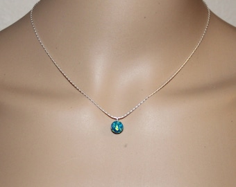 May include: A silver chain necklace with a small, round, blue and green opal pendant.