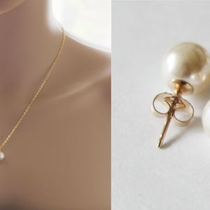 May include: A simple gold chain necklace with a single pearl pendant and a pair of pearl stud earrings.
