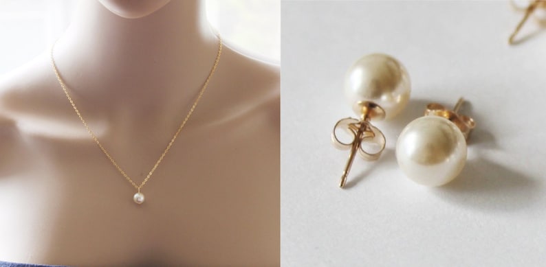 May include: A simple gold chain necklace with a single pearl pendant and a pair of pearl stud earrings.