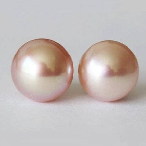 May include: A pair of round, smooth, light pink pearls with a lustrous, reflective surface. Each pearl exhibits a soft, iridescent sheen and a uniform spherical shape, showcasing a delicate pastel color palette and a polished, high-gloss finish.