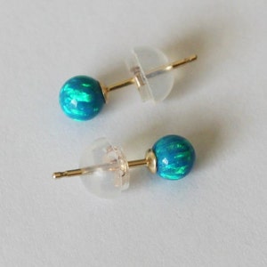 Puede incluir: Un par de pendientes de oro con piedras de &oacute;palo azul. Los pendientes tienen un dise&ntilde;o sencillo y son perfectos para el uso diario.