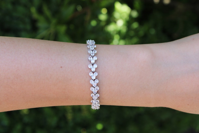 Puede incluir: Un brazalete de plata con una doble fila de piedras de circonita c&uacute;bica transparentes engastadas en forma de coraz&oacute;n.