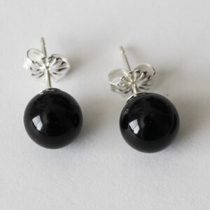 May include: A pair of black onyx stud earrings with silver posts and backs.