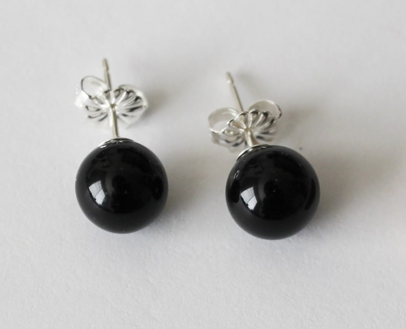 May include: A pair of black onyx stud earrings with silver posts and backs.