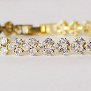May include: A gold bracelet with a double row of clear cubic zirconia stones.