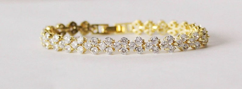 May include: A gold bracelet with a double row of clear cubic zirconia stones.