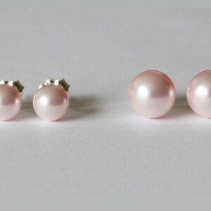 May include: A pair of pink pearl stud earrings. The earrings are set in silver.