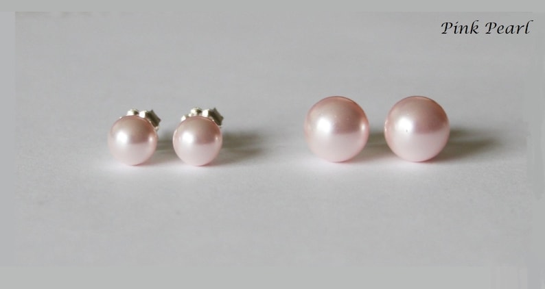 May include: A pair of pink pearl stud earrings. The earrings are set in silver.