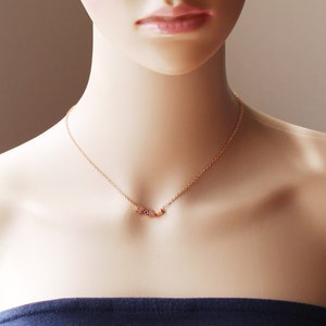 Puede incluir: Un collar de cadena dorada con un colgante que deletrea "LOVE" en letras peque&ntilde;as y c&uacute;bicas.