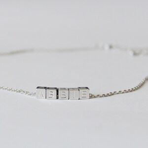 Puede incluir: Un brazalete de cadena de plata con el nombre "ABBIE" escrito en letras de bloque de plata.